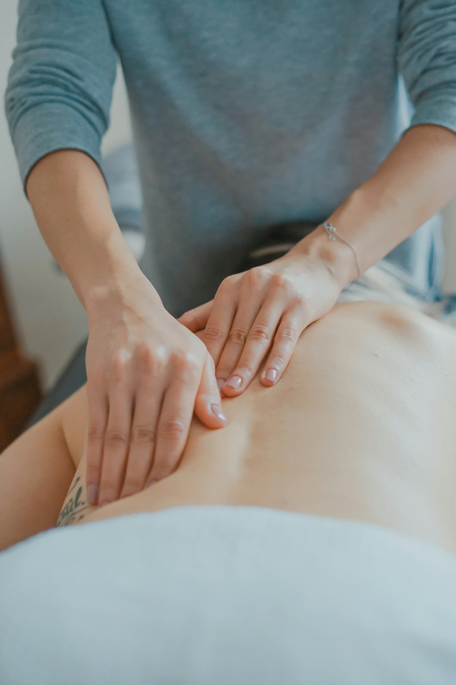 Hands on a person's upper back during treatment