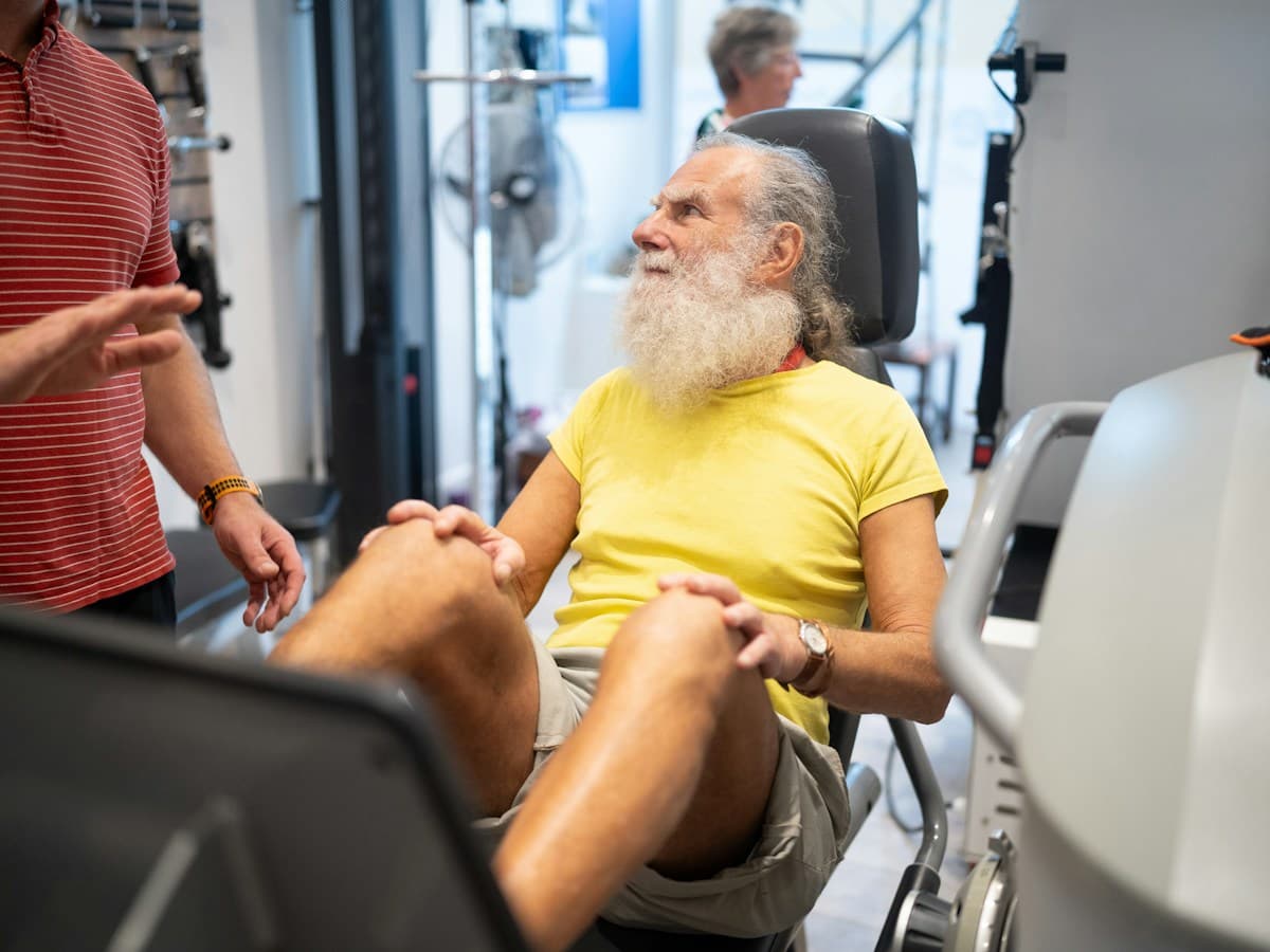 Older adult working on strength and mobility in a supervised rehabilitation gym